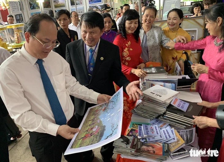 Phó bí thư thường trực Thành ủy TP.HCM Nguyễn Hồ Hải (áo trắng) tham quan các gian hàng hội chợ nhiếp ảnh ở Lễ hội nhiếp ảnh quốc tế TP.HCM lần 1 - Ảnh: MAI THỤY