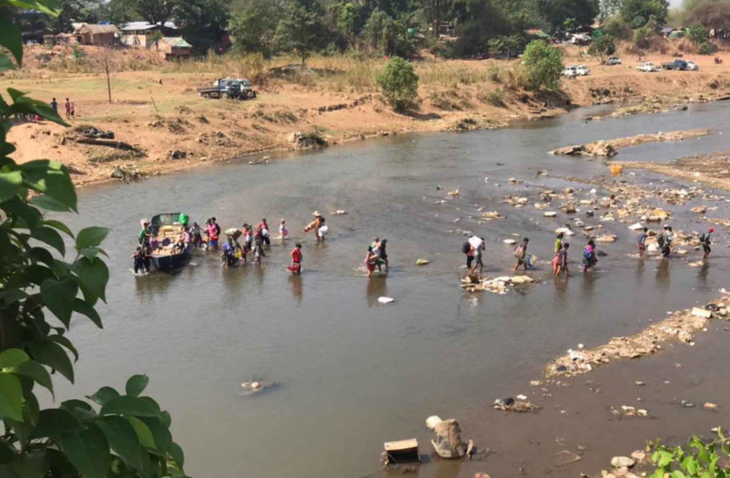 Nhiều người Myanmar vượt sông Moei để đi từ thành phố Myawaddy (Myanmar) đến thành phố Mae Sot (Thái Lan) - Ảnh: ASSAWIN PINITWONG