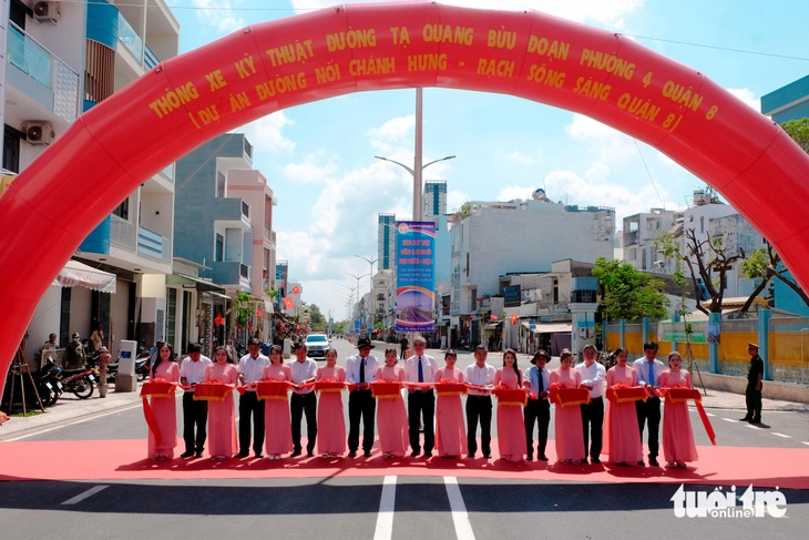 Lãnh đạo TP.HCM, các sở ngành, quận 8 và các đơn vị thực hiện nghi thức cắt băng khánh thành, thông xe đường Tạ Quang Bửu sáng 26-4 - Ảnh: PHƯƠNG NHI