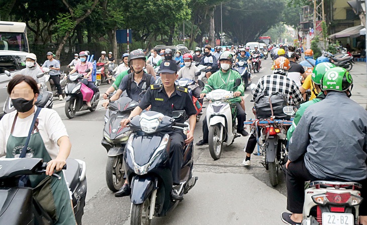 Lái xe máy không đội mũ bảo hiểm, vượt đèn đỏ, chạy ngược chiều sẽ bị phạt nguội. Trong ảnh: giao thông rối loạn góc phố Quốc Tử Giám, Hà Nội sáng 24-4 - Ảnh: T.T.D.