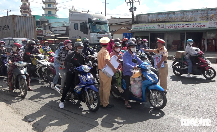 Cảnh sát ôm thùng nước suối và khăn lạnh ra phát trên quốc lộ 1 