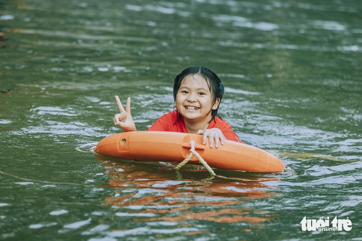 Một em nhỏ thích thú khi được bố mẹ cho học bơi vừa tắm mát trong kỳ nghỉ lễ - Ảnh: RẠNG ĐÔNG