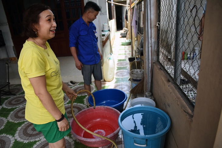 Các gia đình phân công nhau canh chờ lúc có nước, hứng vào xô, chậu, thùng nhựa để sử dụng cho sinh hoạt gia đình - Ảnh: A LỘC