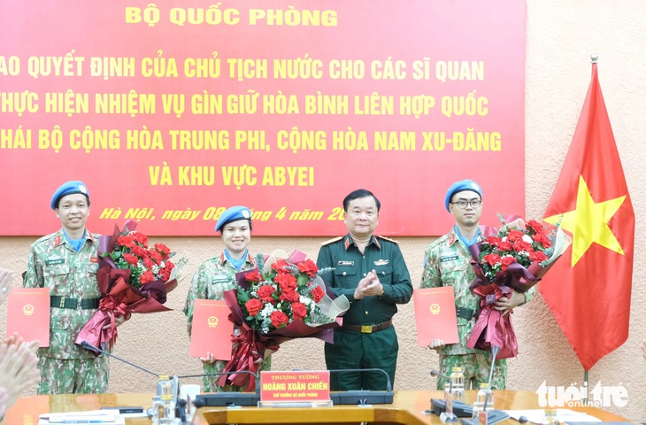 Thượng tướng Hoàng Xuân Chiến - thứ trưởng Bộ Quốc phòng - trao quyết định cho ba sĩ quan đi làm nhiệm vụ gìn giữ hòa bình Liên Hiệp Quốc tại các phái bộ - Ảnh: HÀ THANH