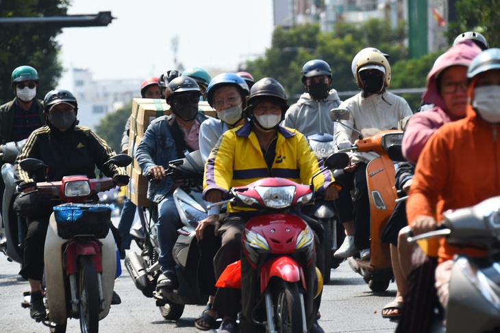 Nắng nóng chạm ngưỡng 40 độ, người đi đường trang bị đủ các dụng cụ tránh nắng (ảnh chụp chiều 8-4 trên đường Lê Văn Sỹ, quận 3, TP.HCM) - Ảnh: TỰ TRUNG