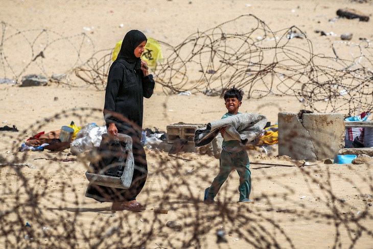 Một gia đình tháo chạy khỏi trại tị nạn ở Rafah thuộc miền nam Gaza ngày 11-5 - Ảnh: AFP