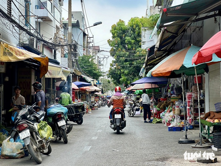 Xe máy lọt thỏm giữa khu chợ tự phát trên đường 26-3 khi mặt đường bị thu hẹp chưa đầy 1m - Ảnh: NGỌC QUÝ