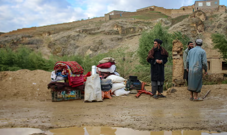 Người dân Afghanistan đứng bên cạnh đồ đạc của mình gần một ngôi nhà bị hư hại vào ngày 18-5 sau lũ quét ở Firozkoh, tỉnh Ghor, Afghanistan - Ảnh: AFP