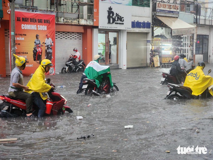 Khu vực đường Kha Vạn Cân, gần chợ Thủ Đức nước ngập sâu hơn nửa bánh xe, nhiều người phải dẫn bộ qua đoạn ngập dài khoảng 500m - Ảnh: MINH HÒA