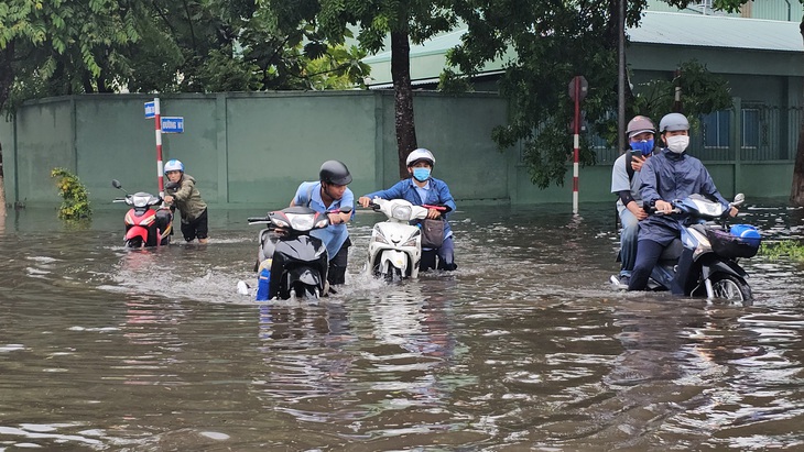 Các công nhân phải lội nước vào chỗ làm tại Khu công nghiệp Giao Long - Ảnh: MẬU TRƯỜNG