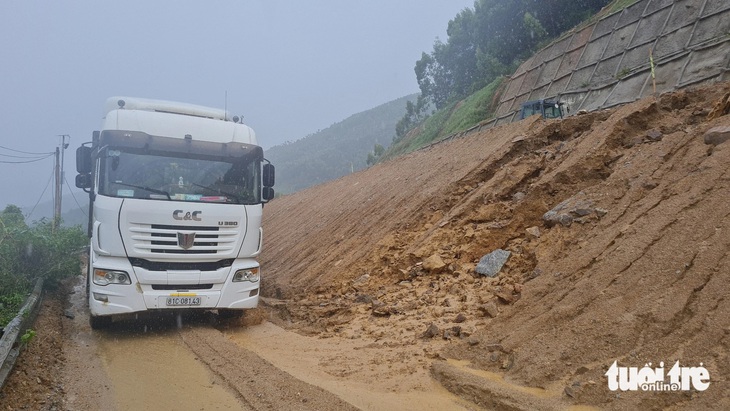 Đất đá theo nước mưa sạt xuống bên dưới phần đường lưu thông theo hướng từ Bình Định lên Gia Lai trên quốc lộ 19 qua đèo An Khê, khiến các phương tiện gặp rất nhiều khó khăn (ảnh chụp chiều 21-5-2024) - Ảnh: LÂM THIÊN