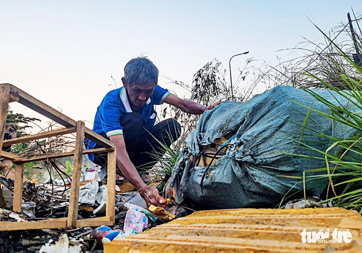 Ông C. (ngoài 60 tuổi, cư ngụ sát bãi rác sau Trường đại học Kinh tế - Luật TP.HCM) phải “tự cứu” bằng cách mỗi tuần vài lần đi đốt rác- Ảnh: Nhóm phóng viên