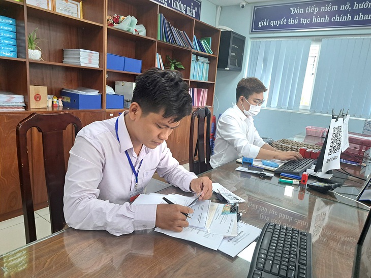 Cán bộ UBND phường Hiệp Bình Chánh, TP Thủ Đức (TP.HCM) đối chiếu hồ sơ, chứng thực bản sao cho người dân - Ảnh: K.YÊN