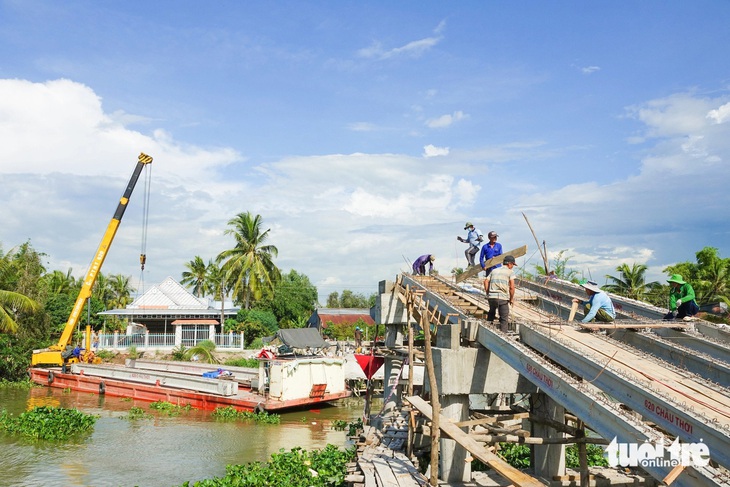 Người dân và đơn vị thi công khắc phục sự cố cầu Kênh 9 - Ảnh: CHÍ CÔNG