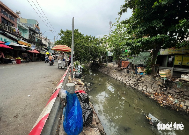 Bờ kênh trở thành điểm để rác. Rác từ đây rơi xuống, khiến cả đống rác vây quanh dòng kênh 19-5. Ảnh chụp trưa ngày 28-5 - Ảnh: TRIỆU VÂN