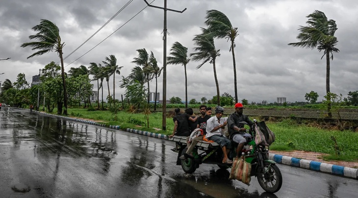 Người dân Ấn Độ di chuyển trong cơn bão tại thành phố Kolkata, Ấn Độ ngày 26-5 - Ảnh: AFP