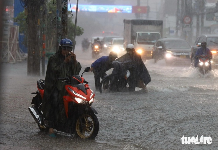 Xe chết máy khi đi qua đoạn ngập trên đường Lê Văn Việt, TP Thủ Đức - Ảnh: NGỌC QUÝ