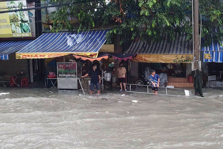 Nước tràn lên bờ, ngập sâu khiến nhiều hộ kinh doanh phải ngừng buôn bán - Ảnh: A LỘC