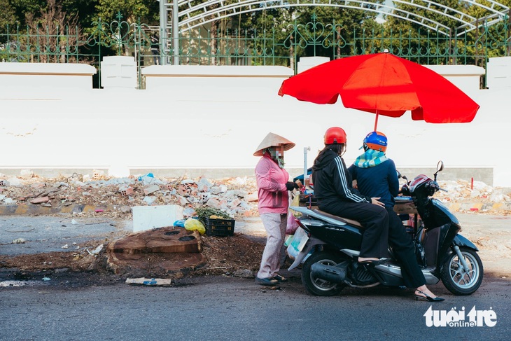 Một xe hàng rong buôn bán ngay cạnh một gốc cây vừa được đốn hạ cho dự án mở rộng đường Hoàng Hoa Thám (quận Tân Bình - TP.HCM) - Ảnh: THANH HIỆP