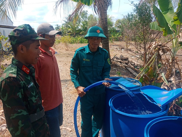 Đoàn đã bơm nước vào các thùng phuy cho bà con vùng xa xôi của xã Phú Mỹ - Ảnh: PHƯƠNG VŨ