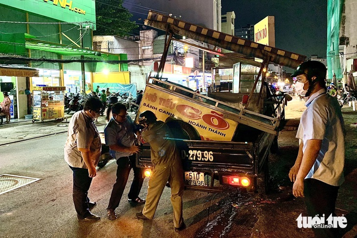 Lực lượng chức năng tạm giữ xe hủ tiếu gõ và mời chủ quán lên trụ sở làm việc - Ảnh: PHƯƠNG NHI