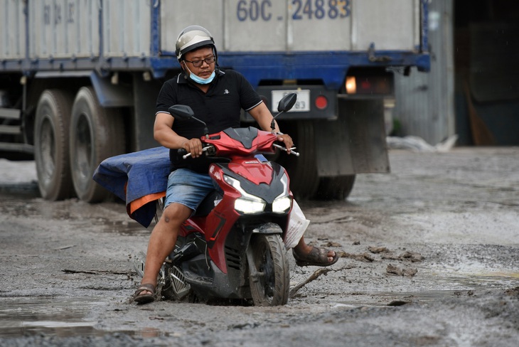 Mỗi ngày có hàng chục người đi xe máy té ngã, ô tô con mắc kẹt, phải nhờ xe cẩu nâng lên khỏi các ổ voi, ổ gà trên đường - Ảnh: A LỘC