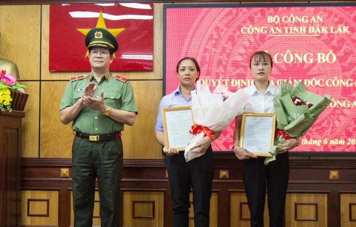 Thiếu tướng Lê Vinh Quy trao quyết định tuyển dụng vợ hai liệt sĩ vào ngành công an - Ảnh: TÂM AN