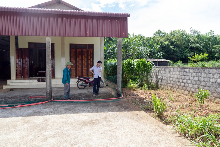 Một phần ngôi nhà kiên cố của ông Bình (phải) nằm trên đất của ông Sơn - Ảnh: HOÀNG TÁO