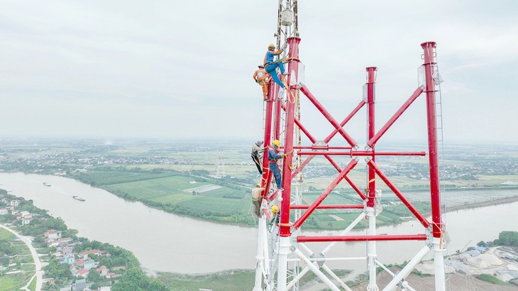 Công nhân đang thi công trên cột điện cao cheo leo - Ảnh: NGUYỄN KHÁNH