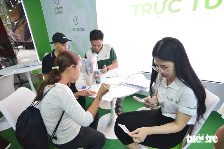 Người dân mở thẻ tại không gian của Vietcombank trong lễ hội - Ảnh: QUANG ĐỊNH