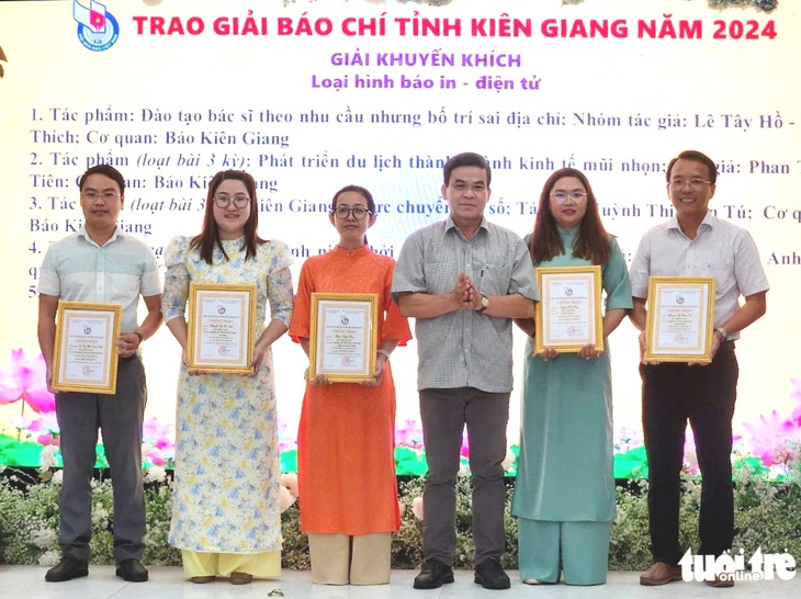 Nhà báo Nguyễn Chí Công (bìa trái) - phóng viên báo Tuổi Trẻ thường trú địa bàn tỉnh Kiên Giang - nhận Giải báo chí tỉnh Kiên Giang năm 2024 - Ảnh: BỬU ĐẤU