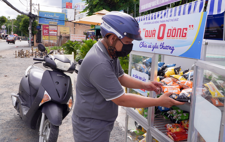 Anh Lê Hữu Thắng đã có những người bạn mới là xe ôm công nghệ khi nghỉ ngơi ở điểm dừng chân này - Ảnh: AN VI