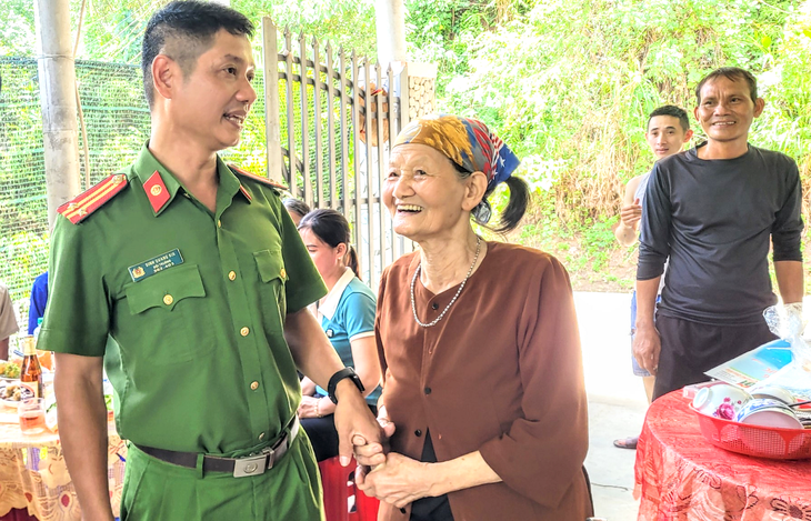 Bà Thắm nắm tay trung tá Đinh Quang Rin nói lời cảm ơn - Ảnh: THANH SU