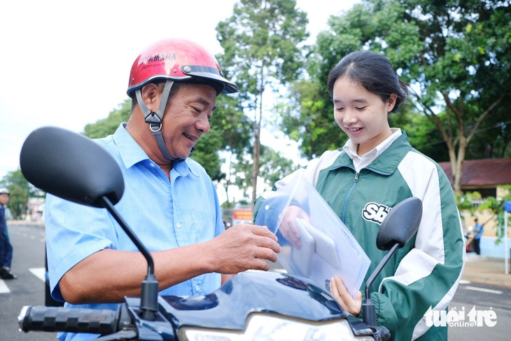 Thí sinh Trần Thị Ngọc Bích, huyện Mang Yang, Gia Lai, được cha đưa đến hội đồng thi và căn dặn kỹ trước lúc vào môn thi đầu tiên - Ảnh: TẤN LỰC