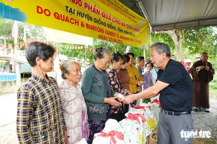 Các nhà hảo tâm hỗ trợ quà cho người dân địa phương nhân sự kiện khánh thành cầu - Ảnh: CHÍ CÔNG