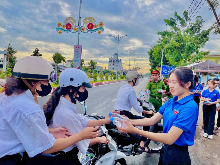 Hơn 250 đoàn viên huyện Hồng Ngự tham gia hỗ trợ thí sinh đi thi năm 2024. Trong ảnh: Tình nguyện viên tại điểm Trường THPT Hồng Ngự 3 phát nước uống cho thí sinh - Ảnh: TỐNG DOANH