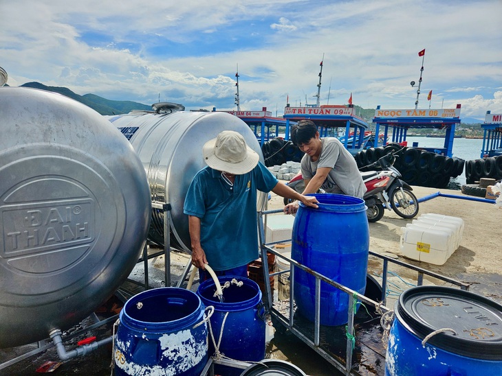 Người dân tranh thủ bơm nước vào các thùng chứa - Ảnh: MINH CHIẾN