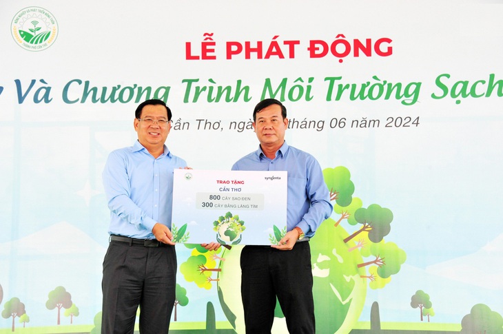 Ông Trần Thanh Vũ - tổng giám đốc Công ty TNHH Syngenta Việt Nam trao biểu trưng tặng hơn một nghìn cây sao và bằng lăng cho ông Cao Văn Ngoan - phó chủ tịch UBND huyện Vĩnh Thạnh, TP Cần Thơ - Ảnh: THU HÀ