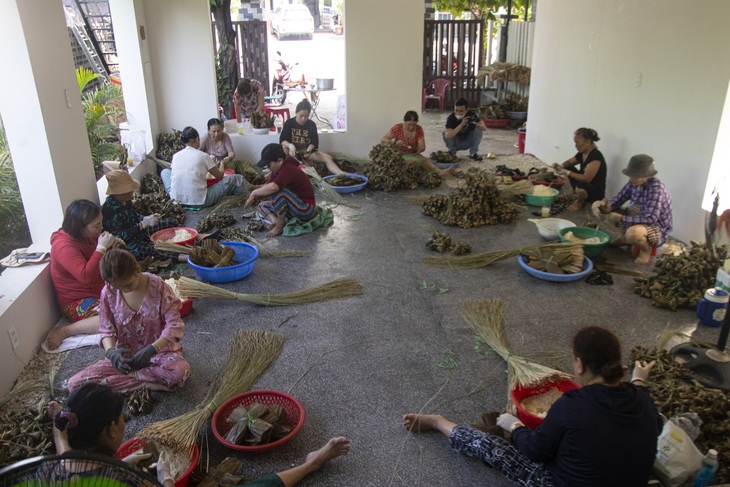 Hàng chục người tập trung tại nhà anh Xin để gói bánh - Ảnh: THANH NGUYÊN