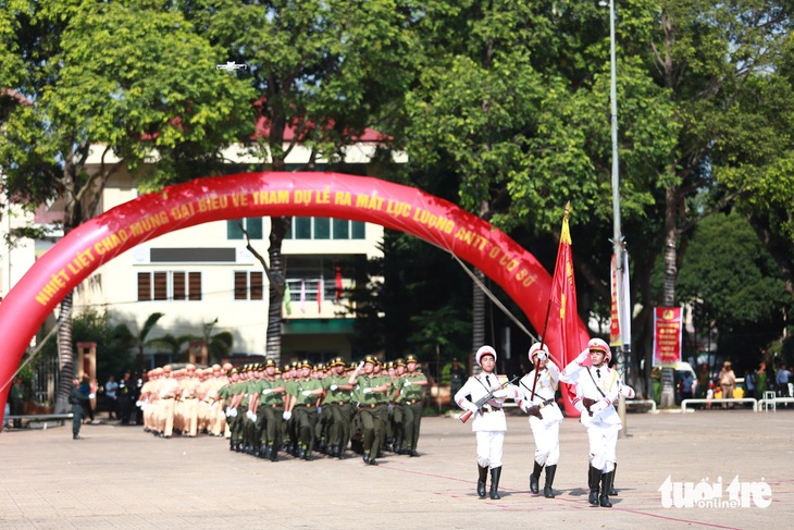 Nghi thức rước cờ trong buổi lễ ra mắt lực lượng tham gia bảo vệ an ninh, trật tự cơ sở - Ảnh: TÂM AN