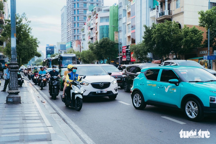 Kẹt xe đã mệt, còn bị ô tô lấn ép hết làn, người đi xe máy phải leo lên lề đường- Ảnh 4.