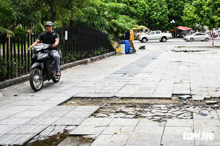 Xe máy đi lên khiến tình trạng vỉa hè bong tróc thêm nghiêm trọng - Ảnh: HỒNG QUANG