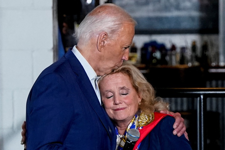 Tổng thống Mỹ Joe Biden hôn hạ nghị sĩ Debbie Dingell khi đến thăm bang Michigan ngày 12-7 - Ảnh: REUTERS