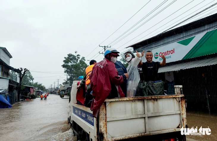 Người dân và du khách được cán bộ, chiến sĩ Công an TP Phú Quốc hỗ trợ xe đưa rước qua đoạn ngập sâu ở ấp Cây Thông Trong (xã Cửa Dương) - Ảnh: CHÍ CÔNG