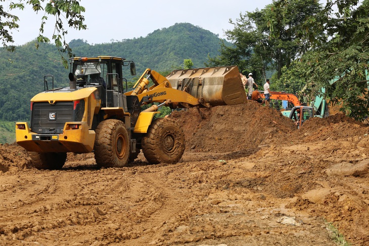 Máy móc được huy động để giải phóng đất đá khỏi hiện trường vụ sạt lở trên quốc lộ 34 - Ảnh: ĐỨC MẠNH