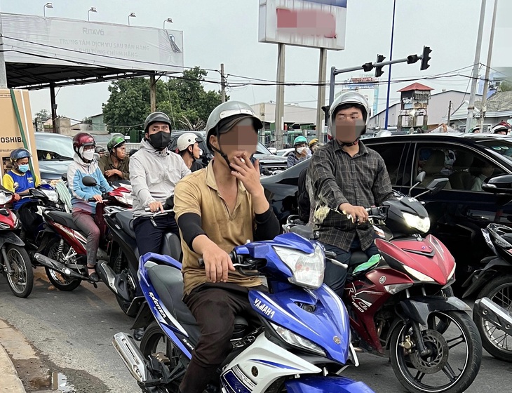 Nam thanh niên phì phèo điếu thuốc trước ánh mắt khó chịu của người xung quanh - Ảnh: XUÂN ĐOÀN