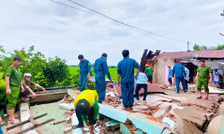 Lực lượng Công an xã Mỹ Lâm (huyện Hòn Đất) giúp dân di dời đồ đạc do ảnh hưởng mưa dông - Ảnh: HOÀNG ĐÔ