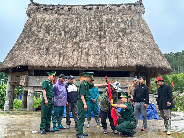 Bộ đội biên phòng Quảng Nam hướng dẫn treo cờ rủ cho bà con xã Ga Ri, huyện Tây Giang - Ảnh: PHÚC TRƯỜNG