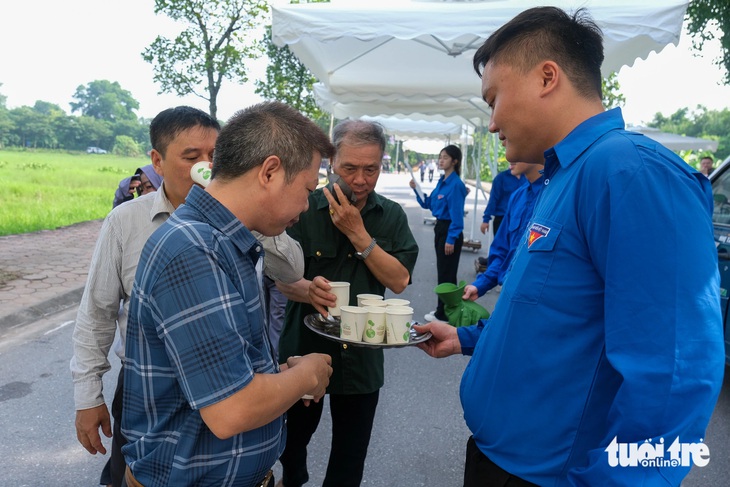 Người dân xếp quạt cây ra đường, pha nước chanh cho người đến viếng Tổng Bí thư Nguyễn Phú Trọng- Ảnh 9.