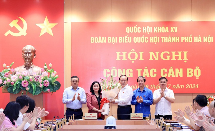 Lãnh đạo Hà Nội cùng Bộ trưởng Bộ Giáo dục và Đào tạo Nguyễn Kim Sơn tặng hoa chúc mừng bà Bùi Thị Minh Hoài - Ảnh: HĐND TP